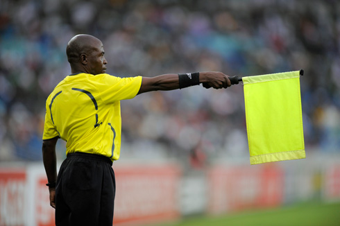 Linesman holding a yellow flag indicating offside